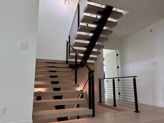 White oak FLIGHT Mono switchback with LED-lit treads and black cable railing