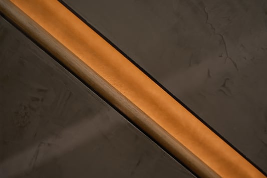 Close view of a wood handrail recessed in a softly lit wall channel.