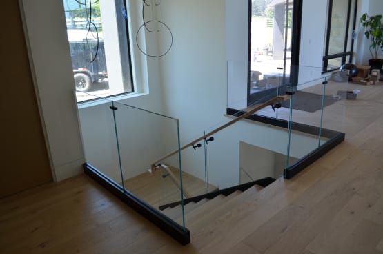 Glass stairwell guard with black base rail