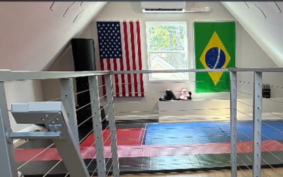 Silver Express cable railing guards a stair opening in an attic gym room.