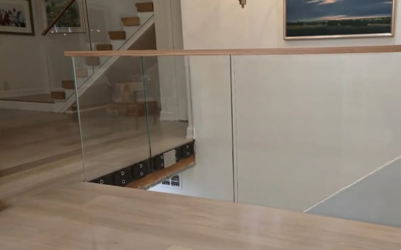 Glass stairwell guard with oak cap