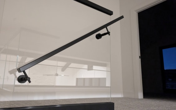 Glass railing with black handrail bracket