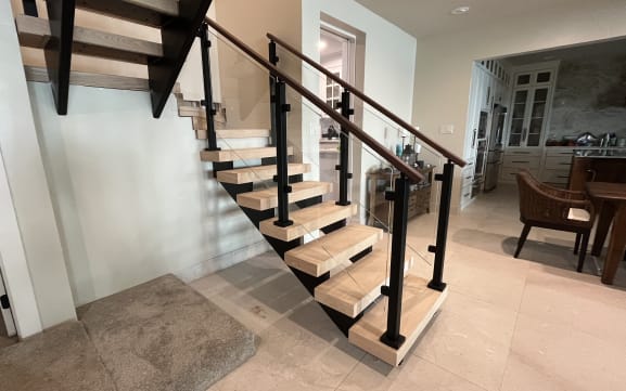 Oak FLIGHT Mono stair with black-post glass railing and walnut handrail in an open kitchen