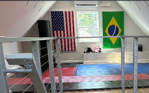 Silver Express cable railing guards a stair opening in an attic gym room.