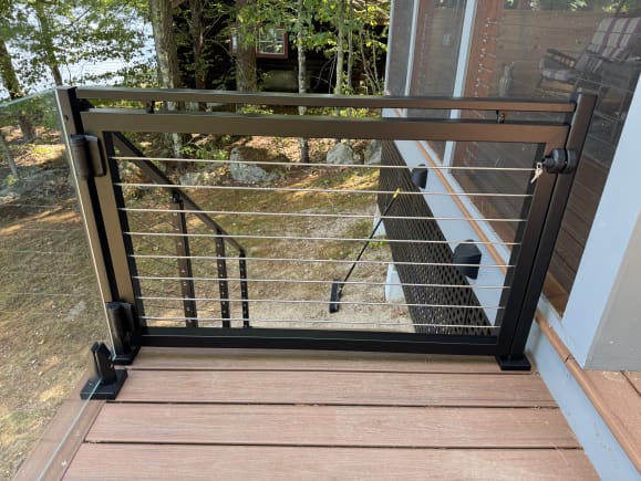 Jet black gate with rod infill between talon-mounted glass and cable stair railing