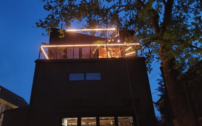 Lit rooftop railing at dusk