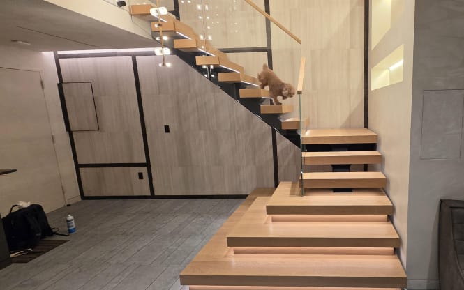 Floating stair with plinths and glass railing