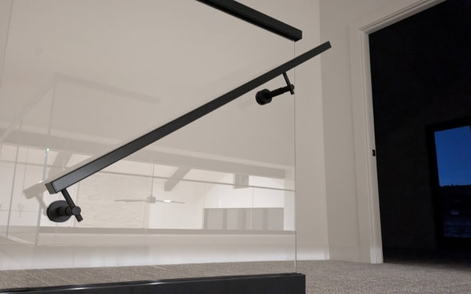 Glass railing with black handrail bracket