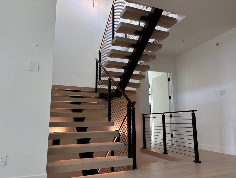 White oak FLIGHT Mono switchback with LED-lit treads and black cable railing